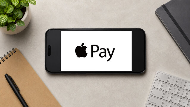 In this photo illustration, a horizontally placed smartphone displays the Apple Pay app logo on a minimalist office desk, in Guwahati, India on 13 August 2026.