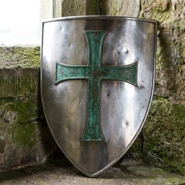 Medieval metal shield with embossed green cross detail.