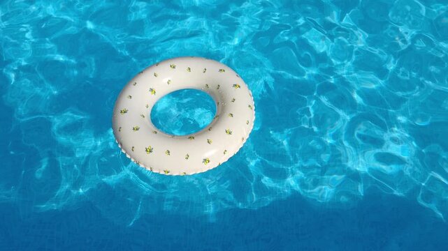 White inflatable swim ring with small floral pattern floating in a bright blue swimming pool, summer vacation and leisure concept, refreshing poolside recreation.