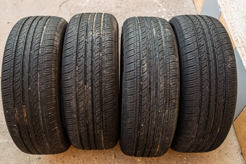 Four Black Car Tires Lined Up on Concrete Surface © lucky pics