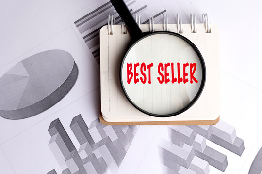 Best seller concept viewed through magnifying glass on notebook with financial charts representing sales performance and market success