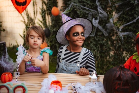 Two girls enjoying Halloween celebration with costumes and decorations outdoors