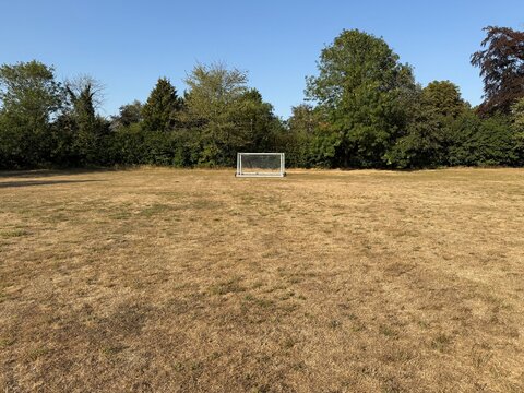 playing field with dried yellowed grass due to the drought this summer in the uk