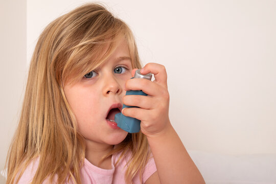Young Girl Using an Asthma Inhaler at Home