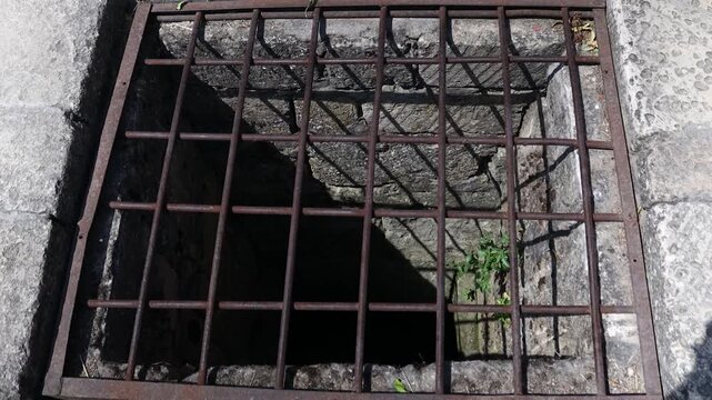 A metal grate with a central hole, suitable for use as a design element or to depict industrial settings