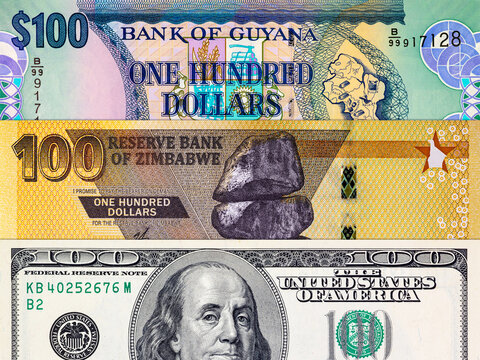 Different 100 Dollars banknotes from the USA, Guyana, and Zimbabwe. Global variety of the dollar as a monetary unit.
