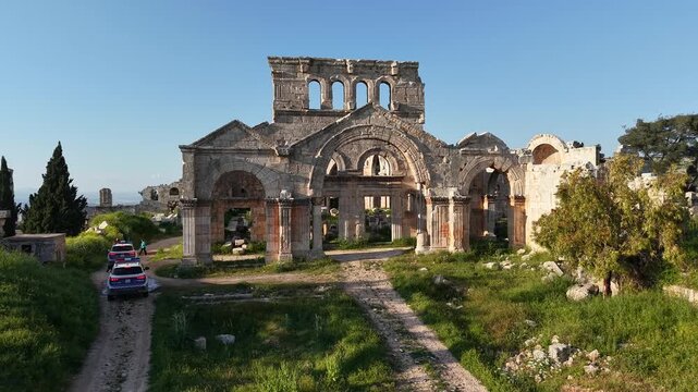 Aerial drone view of the historic ruins of Qal'at Semaan in Syria. Ancient stone architecture and arches at the Church of Saint Simeon Stylites. Famous archaeological site.