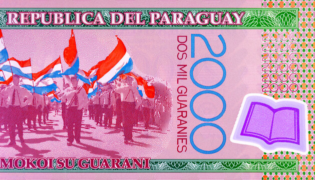 2000 Guaranies Paraguay featuring a parade of students carrying national flags. Colorful polymer currency note from South America. Money of Paraguay.