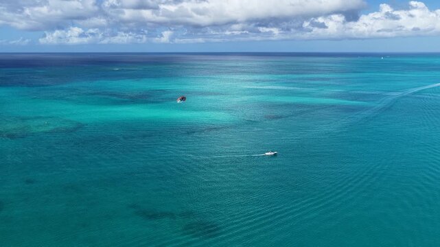 Parasailing In Providenciales Turks And Caicos United Kingdom. Thrilling Adventure With Speedboat Paragliding In Turquoise Ocean. Summer Backgrounds. Bay Water Landscape.