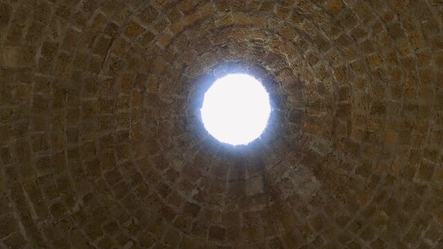A small window in a brick wall with a skylight, suitable for use as a background or texture