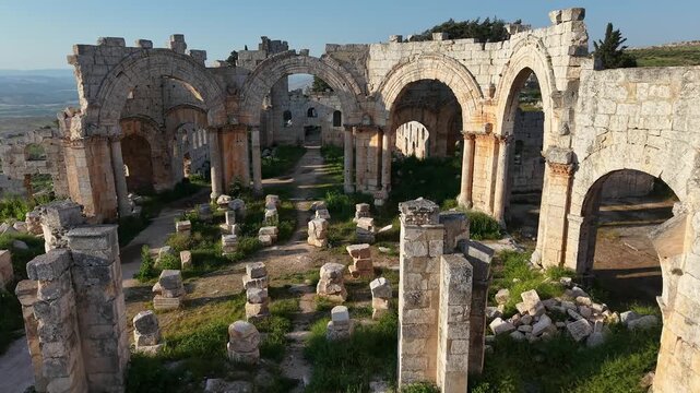 Aerial drone view of the historic ruins of Qal'at Semaan in Syria. Ancient stone architecture and arches at the Church of Saint Simeon Stylites. Famous archaeological site.