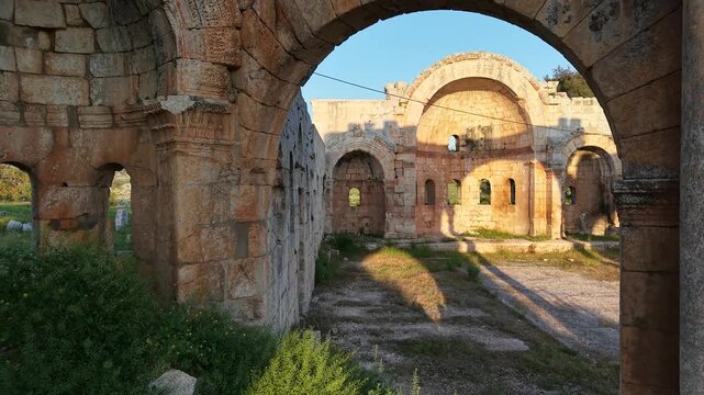 Aerial drone view of the historic ruins of Qal'at Semaan in Syria. Ancient stone architecture and arches at the Church of Saint Simeon Stylites. Famous archaeological site.