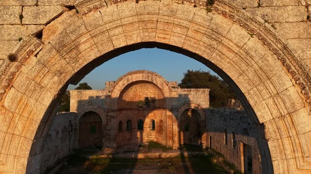 Aerial drone view of the historic ruins of Qal'at Semaan in Syria. Ancient stone architecture and arches at the Church of Saint Simeon Stylites. Famous archaeological site.