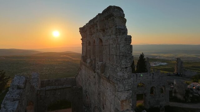 Scenic aerial drone shot of Qal'at Semaan historic site at sunset. Sunset background with an archaeological site. Ancient ruins and heritage in Syria. Tourism in post-war Syria.