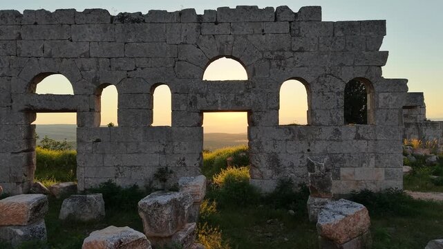 Scenic aerial drone shot of Qal'at Semaan historic site at sunset. Sunset background with an archaeological site. Ancient ruins and heritage in Syria. Tourism in post-war Syria.