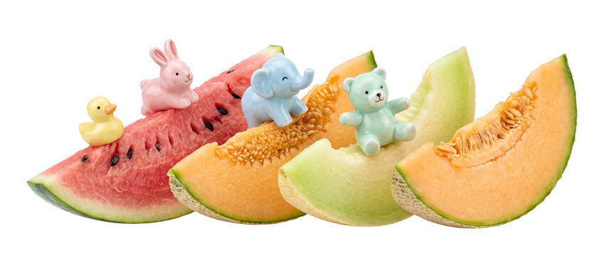 Fresh fruit slices animal figurines sitting on watermelon and melon against black background, featuring cute miniature characters for whimsical summer food design concept, creative arrangement.
