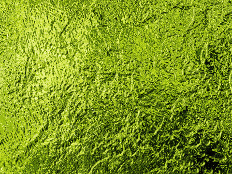 Vibrant lime green abstract texture with a crinkled, metallic surface and a frosted glass effect, suggesting growth and freshness.