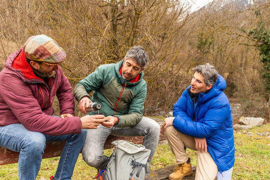 Friends share water during a forest hiking break