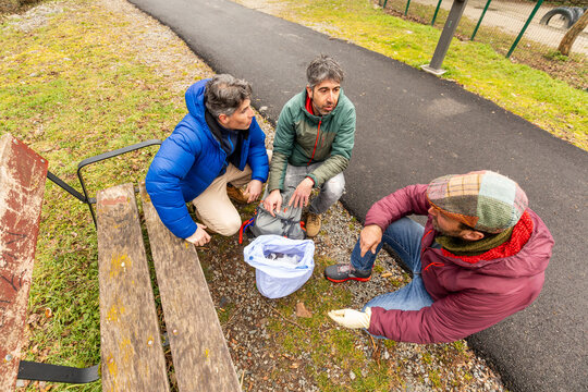 Friends examine collected plastic waste in a park