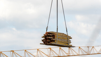 Heavy timber hangs suspended above a crane's lattice structure © I