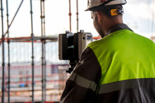 Worker operates laser scanner at construction site