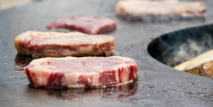 Steak slices sizzle on hot griddle