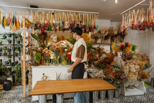 Two young florists buying fresh flowers in a colorful flower shop