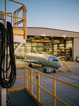 Passenger aircraft undergoing maintenance inside airport hangar