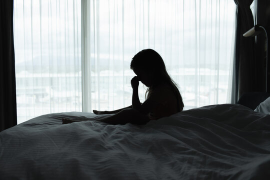 Sad Young Girl Sitting Alone on Bed Feeling Lonely, Stressed and Upset
