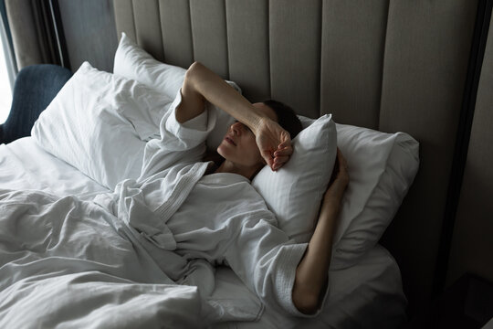 Exhausted Woman Lying in Bed Suffering From Stress, Fatigue and Burnout

