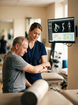 Physiotherapist assess patient with motion analysis screen