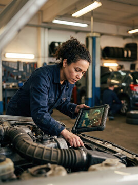 Mechanic use diagnostic tablet to inspect car engine