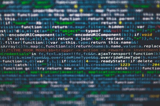 Macro view of software source code on screen with blurred colored text syntax programming software computer
