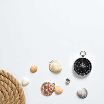 Vintage compass rope and shells on white background nautical flat lay copy space