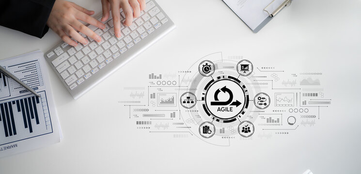 Business Professional Analyzing Market Data with Agile Methodology Icons on Computer Keyboard and White Desk Surface. Entropy.