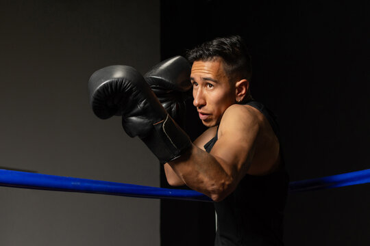 Focused Hispanic boxer in fighting stance ready to strike in ring
