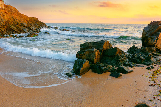 sea beach at sunrise. Bulgaria summer vacation background. colorful sky with glowing clouds. waves, sand and rocks in morning light