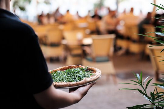 Servicekraft tr&auml;gt im Restaurant Teller bei der Arbeit in der Gastronomie
