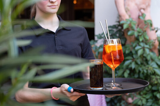 Bedienung tr&auml;gt bei der Arbeit im Restaurant ein Tablett mit Getr&auml;nken