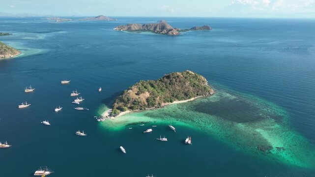 Aerial view of Pulau Kelor surrounded by turquoise waters and boats in Komodo, East Nusa Tenggara, Indonesia.