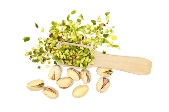  Pistachios chopped pile with nutshell in wooden spoon isolated on white background, top view