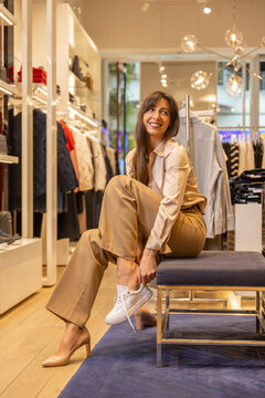 Cute woman trying on new shoes in a fashionable boutique