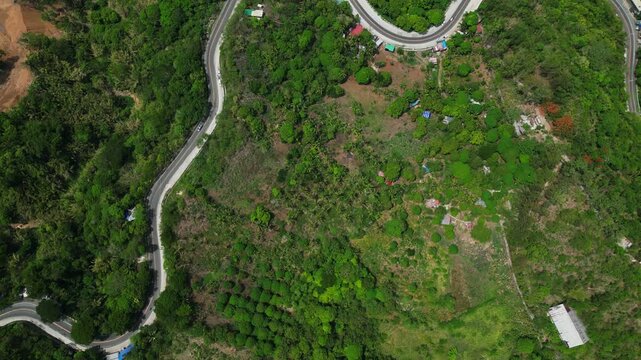 Drone aerial view of a winding roadway in Cambuja, Pililla, Rizal featuring sharp bends, elevated terrain, and the mountainous landscape of Rizal Province.