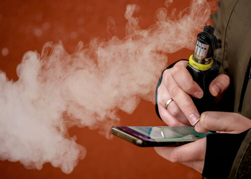 a man smokes an electronic cigarette. VAPE lets smoke