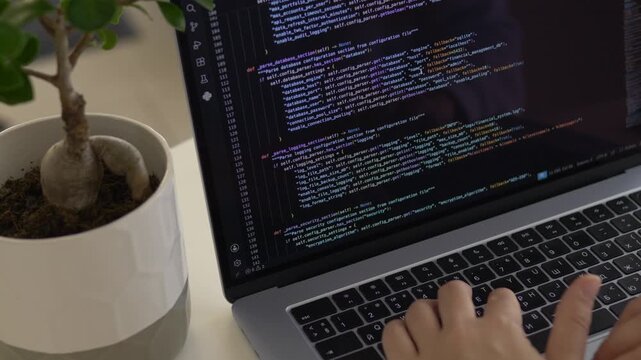 Hands typing programming code on laptop during focused development session. Independent coding, digital productivity and software creation concept.
