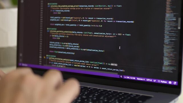 eveloper hands on laptop keyboard with realistic IDE code screen showing status bar at bottom. Authentic professional coding session and vibe coding real environment concept.