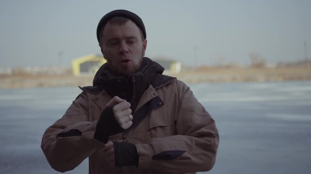 man in cowboy clothes dancing emotionally and energetically outdoors in winter