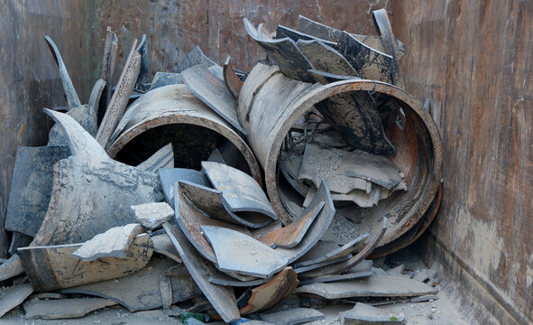 Gusseisen Metall Schrott von ausgedienten Wasserleitungen in einer Abfall Mulde, wertvoller Eisenschrott f&uuml;r den Eisen Schrotthandel von Fe-Metallen, Wiederverwertung und Recycling von Alteisen