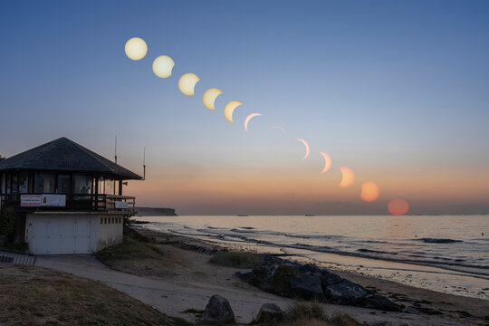 Saint-Come-De-Fresne, France - 08 12 2026: Composite image of the different phases of a partial eclipse covered up to 93,4% over the sea from the beach