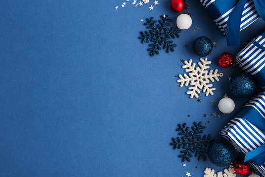 Festive Blue Holiday Gifts and Ornaments with Snowflakes and Stars Composition on Solid Background